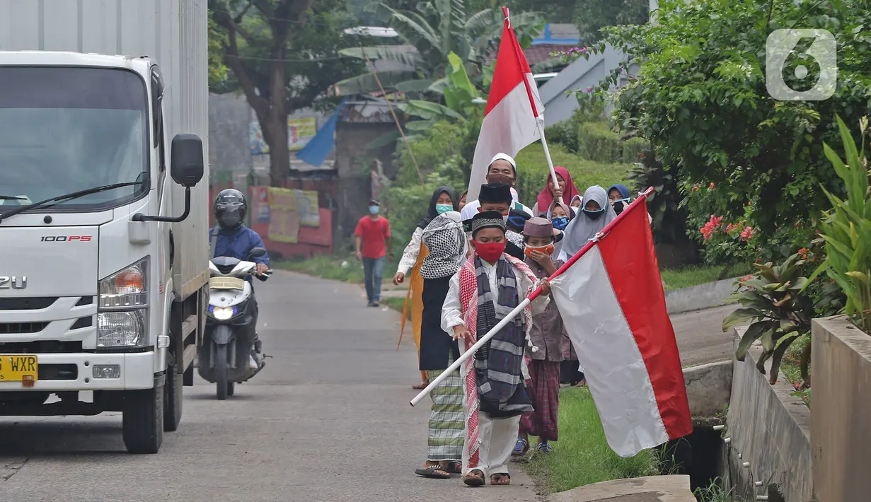 HARI SANTRI NASIONAL: Sejumlah anak pengajian melakukan pawai di Jalan Raya Tapos, Depok, Jawa Barat, Kamis (22/10/2020). Pengajian Kampung Tapos menggelar pawai menyambut Hari Santri Nasional 2020 yang diperingati setiap tanggal 22 Oktober. (Liputan6.com/Herman Zakharia)