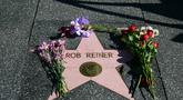 Beberapa bunga diletakkan di bintang Hollywood Walk of Fame milik aktor sekaligus sutradara Amerika Serikat, Rob Reiner, di Los Angeles, California, pada Senin 15 Desember 2025. Dunia perfilman Amerika Serikat berduka atas kepergian Rob Reiner. (Frederic J. Brown/AFP)