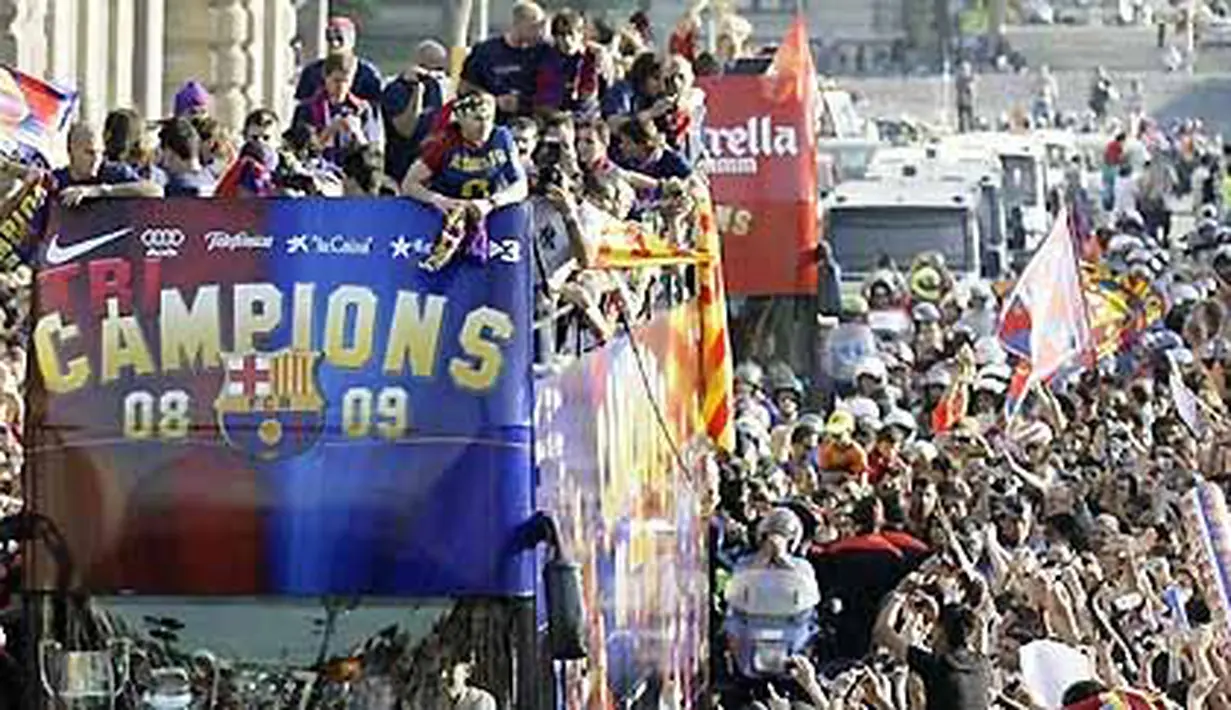 FC Barcelona fans wave to the soccer team as the team travels on an open-topped bus to celebrate their Champions League victory in Barcelona May 28, 2009. AFP PHOTO/JOSEP LAGO