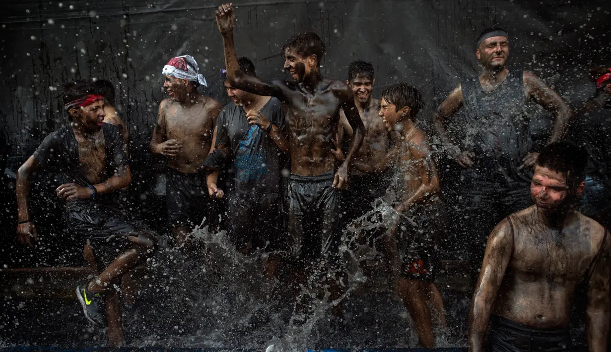 Kemeriahan para peserta berlumur oli saat mengikuti Festival Cascamorras di Baza, Granada, Spanyol, Kamis (6/9). Festval ini dilaksanakan di Kota Baza dan Guadix. (JORGE GUERRERO/AFP)