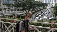 Pekerja melintasi JPO saat kemacetan kendaraan di Jalan Jenderal Sudirman, Jakarta, Senin (15/5/2023). (merdeka.com/Iqbal S Nugroho)