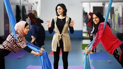 Instruktur yoga asal Palestina, Amal Khayal memberikan sesi latihan aerial flow yoga di pusat pelatihan yoga wanita pertama di kota Gaza, 28 Maret 2018. Khayal juga memimpin berbagai kegiatan untuk perempuan di badan amal Italia. (MOHAMMED ABED/AFP)