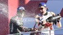 Marc Marquez dengan menyemprotkan champagne usai meraih gelar juara dunia MotoGP 2017 pada balapan MotoGP Valencia di Ricardo Tormo Circuit, Cheste, (12/11/2017). Gelar tersebut merupakan yang keempat buat Marquez di MotoGP. (AFP/Jose Jordan)