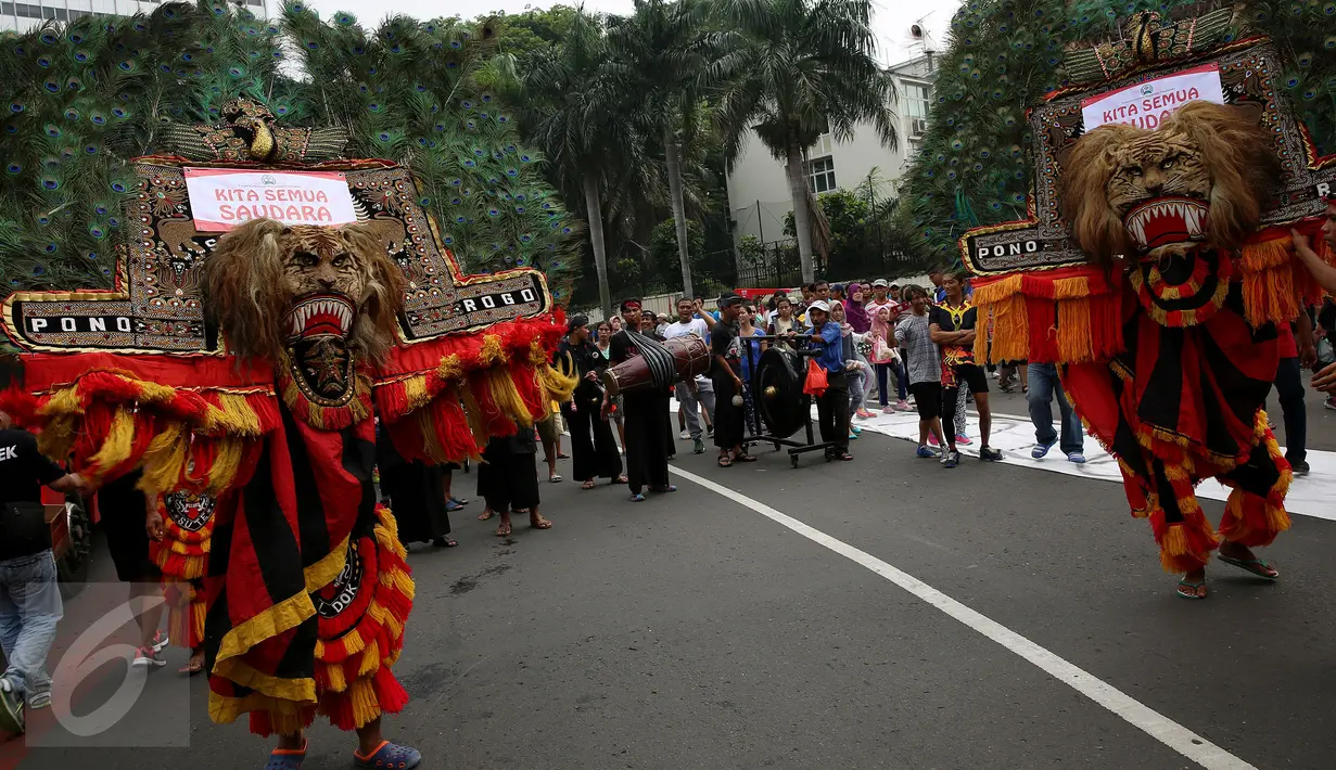 Sejumlah penari Reog Ponorogo adat Ponogoro menghibur pengunjung Car Free Day di Bundaran HI, Jakarta, Minggu (27/11).  Tarian ini sebagai bentuk solidaritas saling menghargai satu sama lain. (Liputan6.com/Johan Tallo)