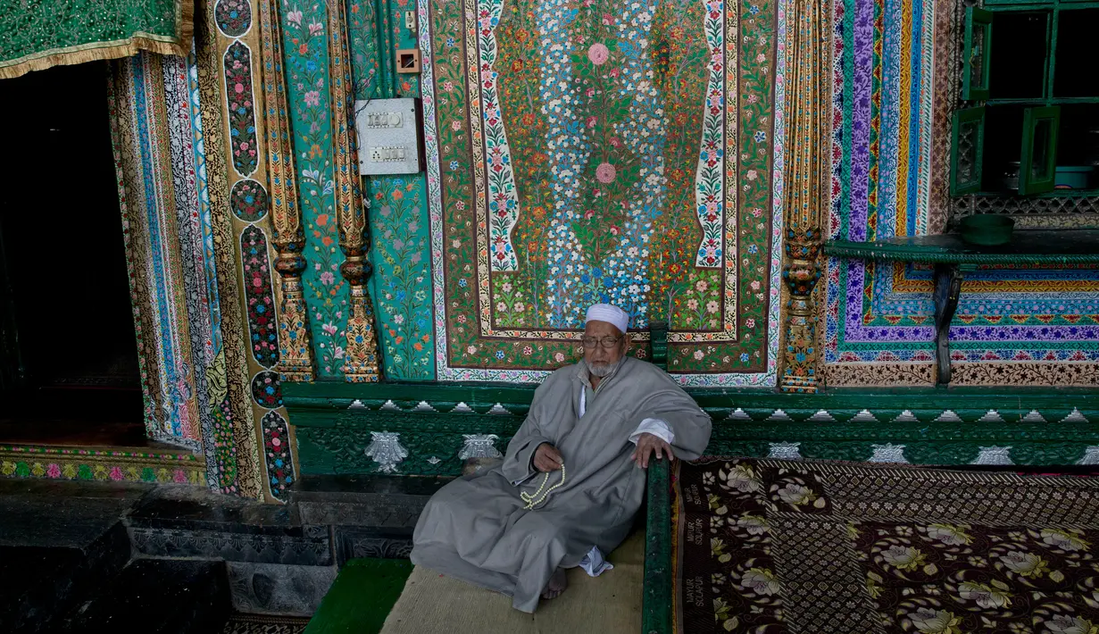 Pria Kashmir berzikir di dekat pintu masuk masjid tertua Masjid Shah-e-Hamdan selama bulan ramadan di Srinagar, Kashmir yang dikuasai India, 9 Mei 2019. Umat Islam di seluruh dunia sedang menjalankan puasa Ramadan dengan menahan lapar, haus, dan hawa nafsu mulai fajar hingga senja. (AP/Dar Yasin)