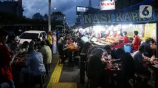 Warga menikmati waktu serta menu berbuka puasa di Sentra Kuliner Nasi Kapau di Jalan Kramat Raya, Senen, Jakarta, Senin (17/3/2025). (Liputan6.com/Herman Zakharia)