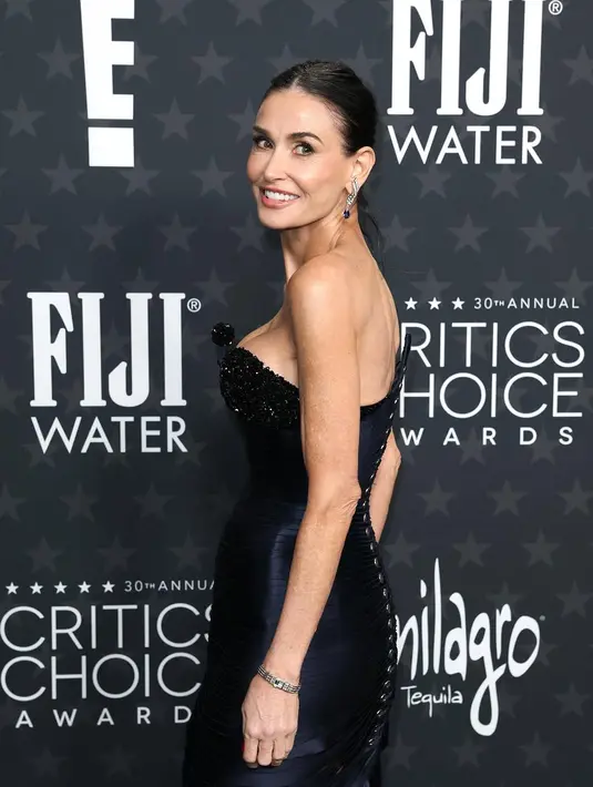 Tampilannya makin sensasional dengan rambut hitam disisir ke belakang dan sanggul balerina yang ramping [@criticschoice]