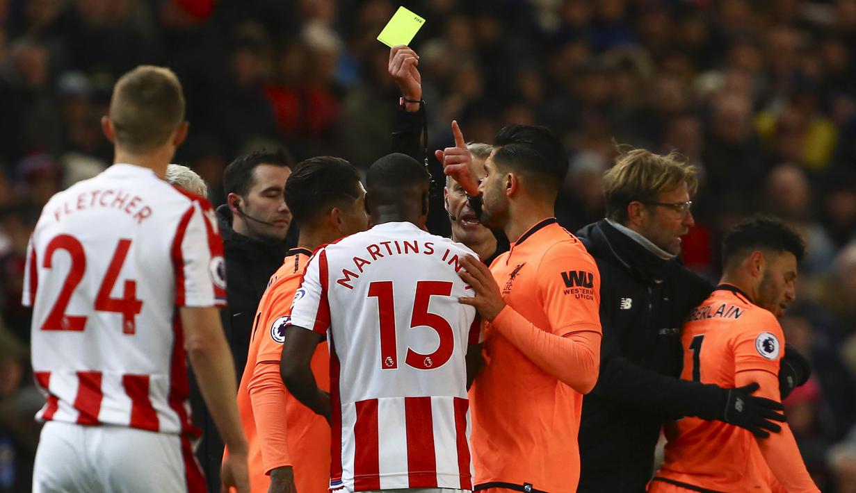 Wasit memberikan karu kuning kepada gelandang Liverpool, Alex Oxlade-Chamberlain dan bek Stoke, Bruno Martins Indi pada laga Premier League di Stadion Bet365, Stoke-on-Trent, Rabu (29/11/2017). Stoke kalah 0-3 dari Liverpool. (AFP/Geoff Caddick)