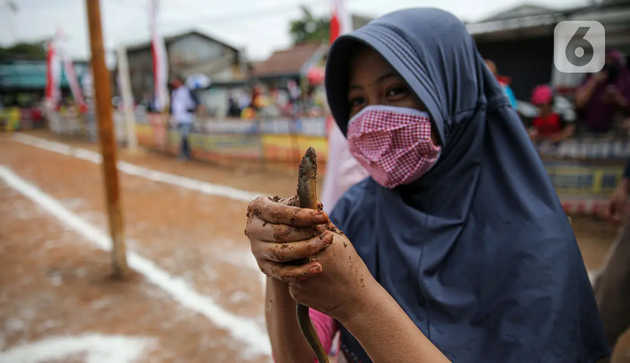 Seorang anak ikut serta dalam lomba menangkap belut dengan menerapkan protokol Kesehatan di kawasan Pondok Cabe IV, Tangerang Selatan, Senin (17/8/2020). Lomba tersebut digelar untuk menyemarakkan HUT ke-75 Kemerdekaan Republik Indonesia. (merdeka.com/Faizal Fanani)