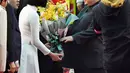 Pemimpin Korea Utara, Kim Jong-un mendapat buket bunga setibanya di Stasiun Dong Dang di Lang Son, Selasa (26/2). Sejumlah pejabat tinggi Vietnam menyambut Kim dengan menggelar karpet merah dan sambutan kenegaraan. (Minoru Iwasaki/Kyodo News via AP)