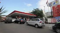 Sejumlah mobil  mengantri bahan bakar minyak di SPBU Cikini, Jakarta, Jumat (16/1/15). (Liputan6.com/Herman Zakharia)