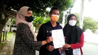 Yuliharni, Ibunda Gio terdakwa pencurian Ponsel menunjukkan surat perjanjian damai bersama korban Budi teman sekolaj Gio. (Liputan6.com/Yuliardi Hardjo)