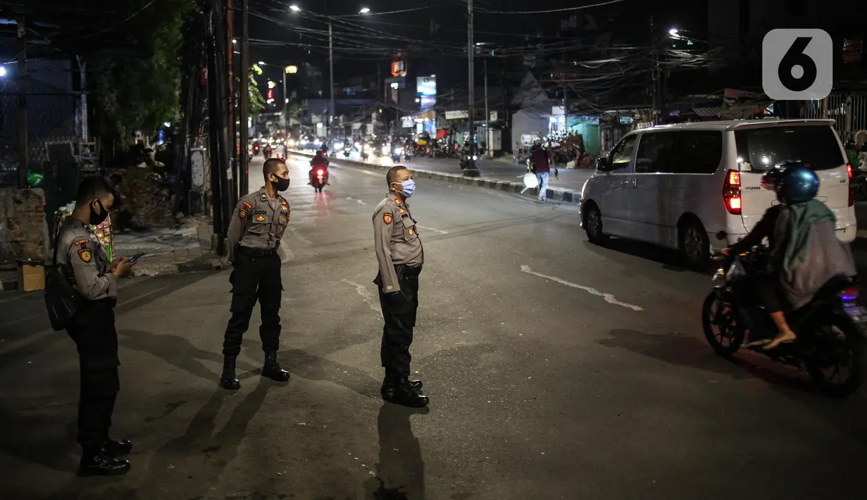 Polisi berjaga pada malam takbiran di Jalan KH Mas Mansyur, Jakarta, Sabtu (23/5/2020). Polisi dikerahkan menjaga Jalan KH Mas Mansyur untuk mengantisipasi adanya takbir keliling di kawasan tersebut. (Liputan6.com/Faiza Fanani)