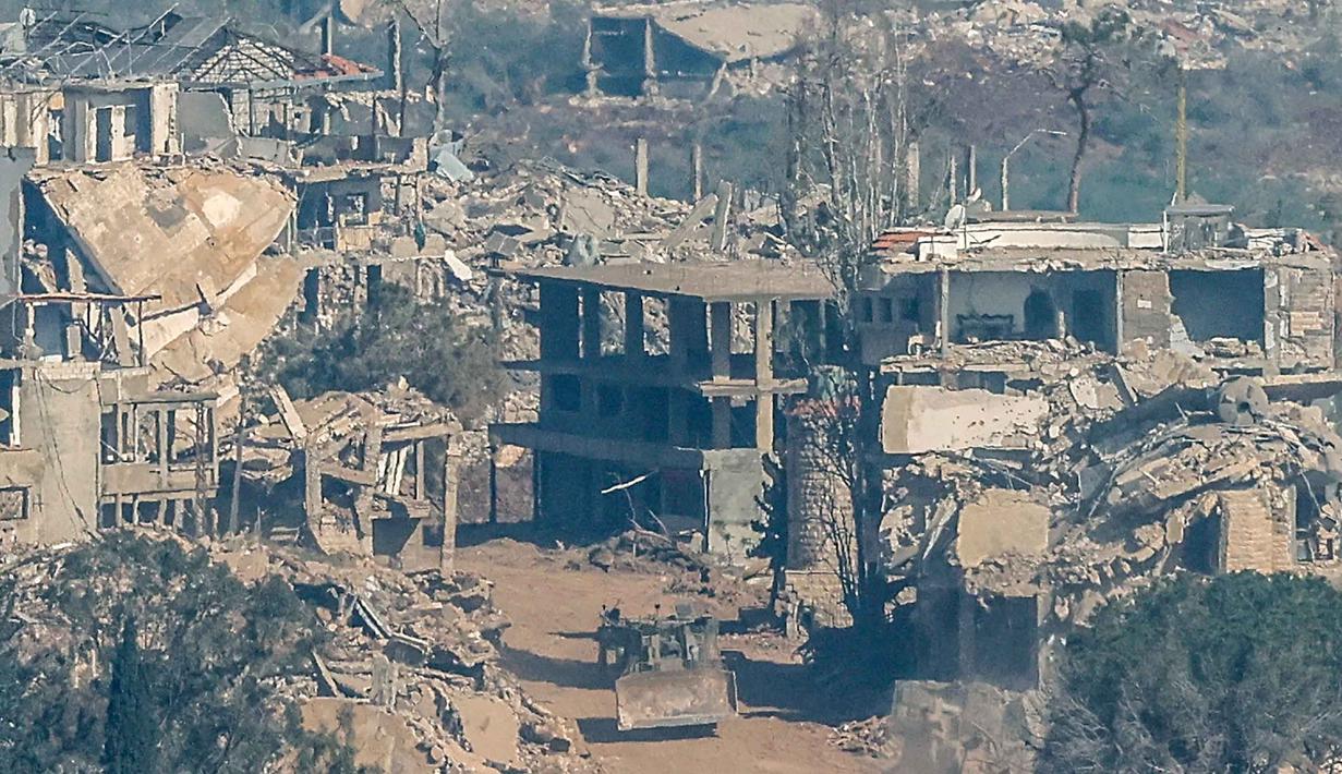 Foto menunjukkan sebuah kendaraan militer Israel melaju di antara rumah-rumah yang hancur di Lebanon Selatan, pada Senin 27 April 2026. (Jalaa MAREY/AFP)