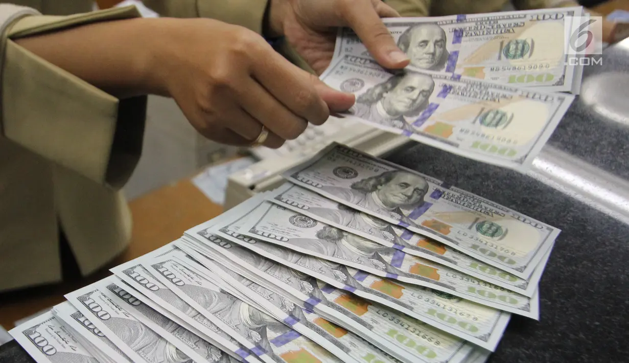 Teller tengah menghitung mata uang dolar di penukaran uang di Jakarta, Junat (23/11). Nilai tukar dolar AS terpantau terus melemah terhadap rupiah hingga ke level Rp 14.504. (Liputan6.com/Angga Yuniar)