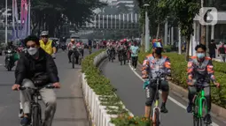 Sejumlah warga berolahraga melintas di kawasan Sudirman - Thamrin saat akhir pekan, Jakarta, Minggu (20/2/2022). Aktivitas warga di kawasan tersebut relatif ramai saat Pemberlakuan Pembatasan Kegiatan Masyarakat (PPKM) level tiga di ibu kota. (Liputan6.com/Johan Tallo)