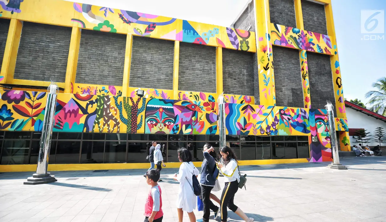 Sejumlah warga berjalan di dekat karya seni Mural di Taman Ismail Marzuki (TIM), Cikini, Jakarta, Selasa (11/9). Mural tersebut dibuat oleh seniman asal Kolombia Diana Ordonez. (Liputan6.com/Faizal Fanani)