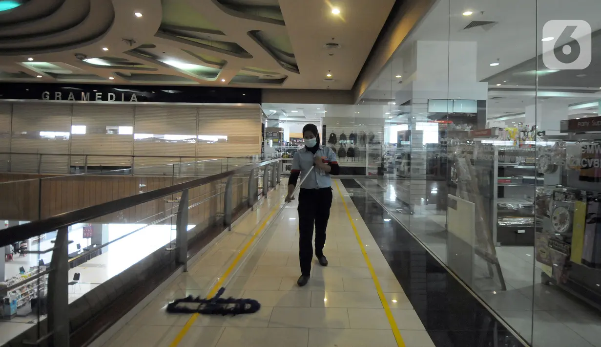 Petugas kebersihan mengepel lantai di Teras Kota Mall, BSD, Tangerang Selatan, Banten, Kamis (22/7/2021). Pemerintah Kota Tangerang Selatan menutup sementara pusat perbelanjaan/mal/pusat perdagangan. (merdeka.com/Arie Basuki)
