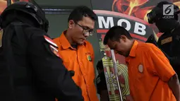 Tersangka pencurian dan pembunuhan sadis terhadap Jeanne Setyadi (78) tertunduk di Polda Metro Jaya, Jakarta, Kamis (26/7). MIF, pelaku utama pencurian dan pembunuhan terhadap nenek Jeanne ternyata masih tetangga korban. (Liputan6.com/Immanuel Antonius)