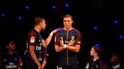Striker PSG, Kylian Mbappe, memegang patung lilin rupa dirinya di Museum Grevin, Paris, Kamis (17/5/2018). Patung ini merupakan apresiasi karena keberhasilannya meraih gelar pemain muda terbaik dan trofi Liga Prancis. (AFP/Christophe Simon)