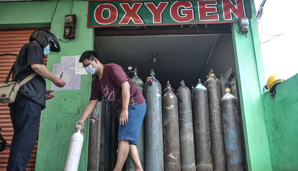 Pekerja melayani pelanggan isi ulang oksigen di agen isi ulang oksigen kawasan Kalimalang, Jakarta, Rabu (27/1/2021). Arif, salah seorang pekerja mengungkapkan permintaan oksigen untuk kebutuhan medis rumahan meningkat 50 persen sejak pandemi Covid-19 mewabah di Jakarta (merdeka.com/Iqbal S Nugroho)