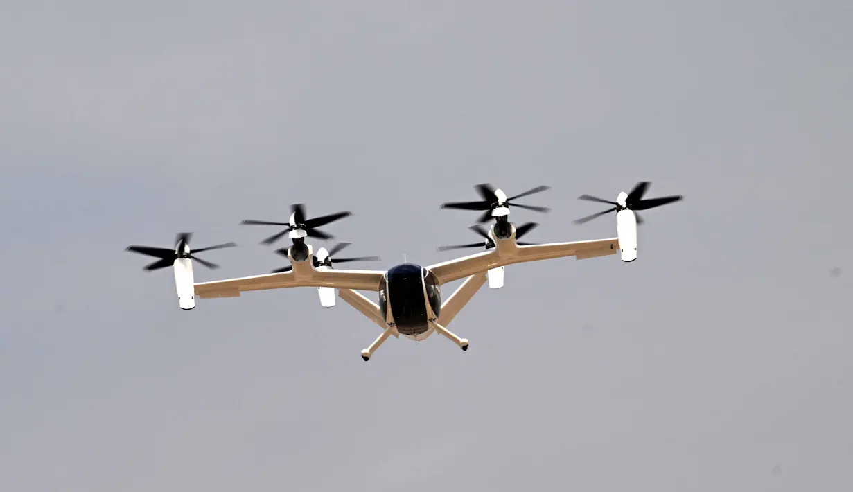 Penerbangan uji coba ini berlangsung pada 17 November 2025, menempuh rute 17 menit dari Helipad Dubai Jetman di Margham menuju Bandara Internasional Al Maktoum (DWC), tempat Dubai Airshow diadakan. Tampak dalam foto, sebuah taksi udara listrik Joby melakukan pertunjukan terbang di Bandara Internasional Al-Maktoum selama Pameran Udara Dubai 2025 pada 17 November 2025. (Giuseppe CACACE/AFP)