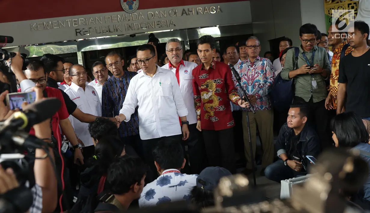 Menpora Imam Nahrawi menyalami pewarta usai menyampaikan keterangan terkait pengunduran dirinya dari jabatan Menteri Pemuda dan Olahraga di Jakarta, Kamis (19/9/2019). Sebelumnya, KPK menetapkan Imam Nahrawi sebagai tersangka kasus suap dana hibah KONI. (Liputan6.com/Helmi Fithriansyah)