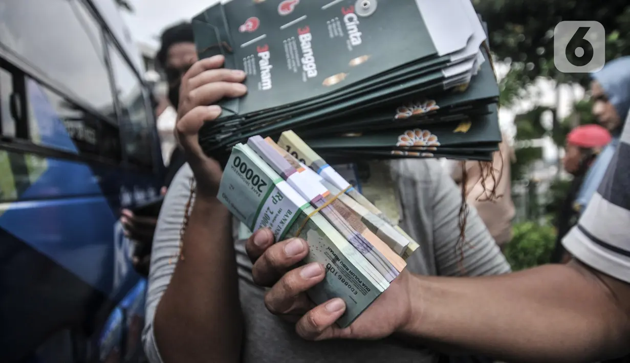 Warga menunjukkan uang pecahan kecil usai ditukarkan di mobil Kas Keliling BI, Pasar Rawa Bening, Jatinegara, Jakarta Timur, Senin (18/4/2022). BI menyiapkan 5.013 titik penukaran uang pada 262 bank umum di seluruh Indonesia sejak 4 April 2022 hingga 29 April 2022. (merdeka.com/Iqbal S.Nugroho)