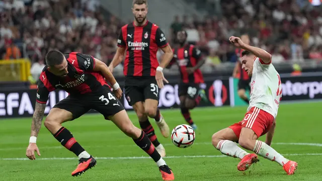 Pemain AC Milan Strahinja Pavlovic berebut bola dengan pemain Benfica Heorhiy Sudakov