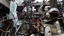 Seorang pemadam kebakaran memeriksa dan mencari korban di puing-puing bekas ledakan pabrik di Dhaka, Bangladesh (4/7). Akibat ledakan tersebut 10 orang tewas dan puluhan lainnya mengalami luka cukup serius. (AFP Photo/Munir Uz Zaman)