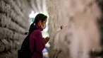 Seorang wanita berdoa di depan lentera teratai putih dengan nama dan doa tertulis pada atasnya setelah kebaktian untuk merayakan ulang tahun Buddha di Kuil Jogye, Seoul, Korea Selatan, Minggu (8/5/2022). (ANTHONY WALLACE/AFP)