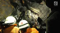Petugas menemukan dua jasad yang sudah hangus terbakar di dalam puing minibus yang ringsek usai  kecelakaan kereta api di perlintasan Kramat, Senen, Jakarta, Selasa (13/6). (Liputan6.com/Helmi Afandi)