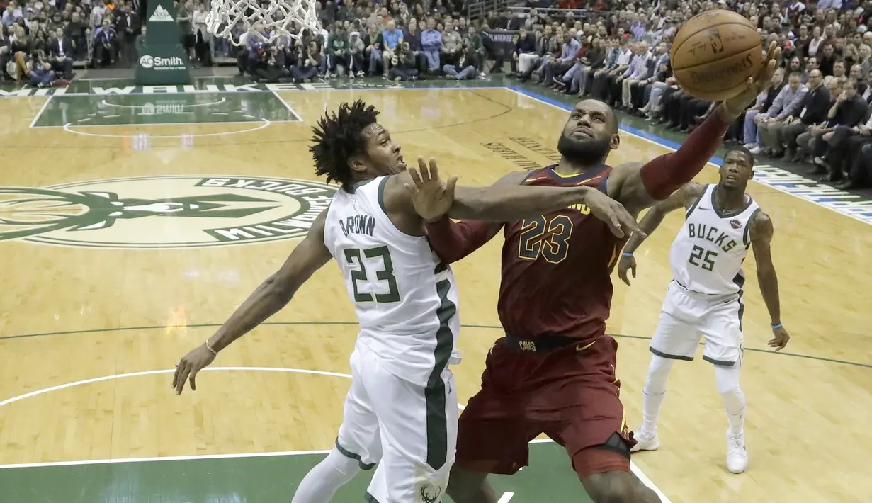 Pemain Cleveland Cavaliers, LeBron James melakukan layup melewati adangan pemain Milwaukee Bucks, Sterling Brown pada laga NBA basketball game di BMO Harris Bradley Center, Milwaukee, (19/12/2017). Bucks menang 119-116. (AP/Morry Gash)