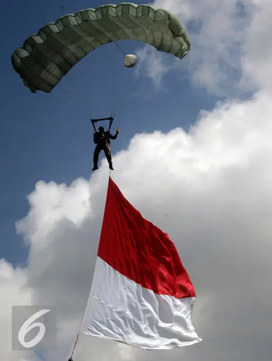 Penerjun membawa bendera merah putih saat aksi di acara masa orientasi mahasiswa baru di kampus UGM, Yogyakarta, Senin (1/8). Masa orientasi diikuti ribuan mahasiswa baru yang akan berlangsung hingga 6 Agustus. (Liputan6.com/Boy Harjanto)