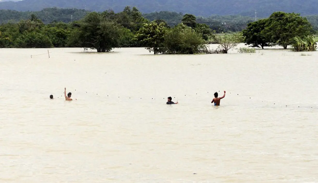 Sejumlah warga memanfaat banjir untuk menjaring ikan Kota Condon, Ilocos sur, Filipina, Senin (24/8/2015). Banjir tersebut akibat hujan deras yang dibawa oleh Topan Goni yang kini diperkirakan menuju Jepang. (AFP Photo)