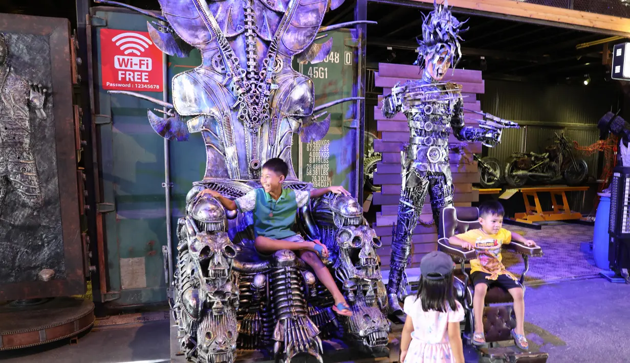 Anak-anak bermain di "Ban Hun Lek", atau "Rumah Robot Baja", di Provinsi Ang Thong, Thailand tengah (5/6/2020). Didirikan pada 2000, "Rumah Robot Baja" adalah bengkel yang dikenal untuk membuat "seni logam bekas" dari limbah suku cadang kendaraan bermotor. (Xinhua/Zhang Keren)