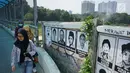 Pejalan kaki melewati poster 13 aktivis yang hilang di kawasan Beji, Depok, Jawa Barat, Selasa (18/6/2019). Poster tersebut mengingatkan masyarakat masih ada pekerjaan rumah pemerintah berupa pelanggaran HAM berat yang belum tuntas hingga kini. (Liputan6.com/Immanuel Antonius)