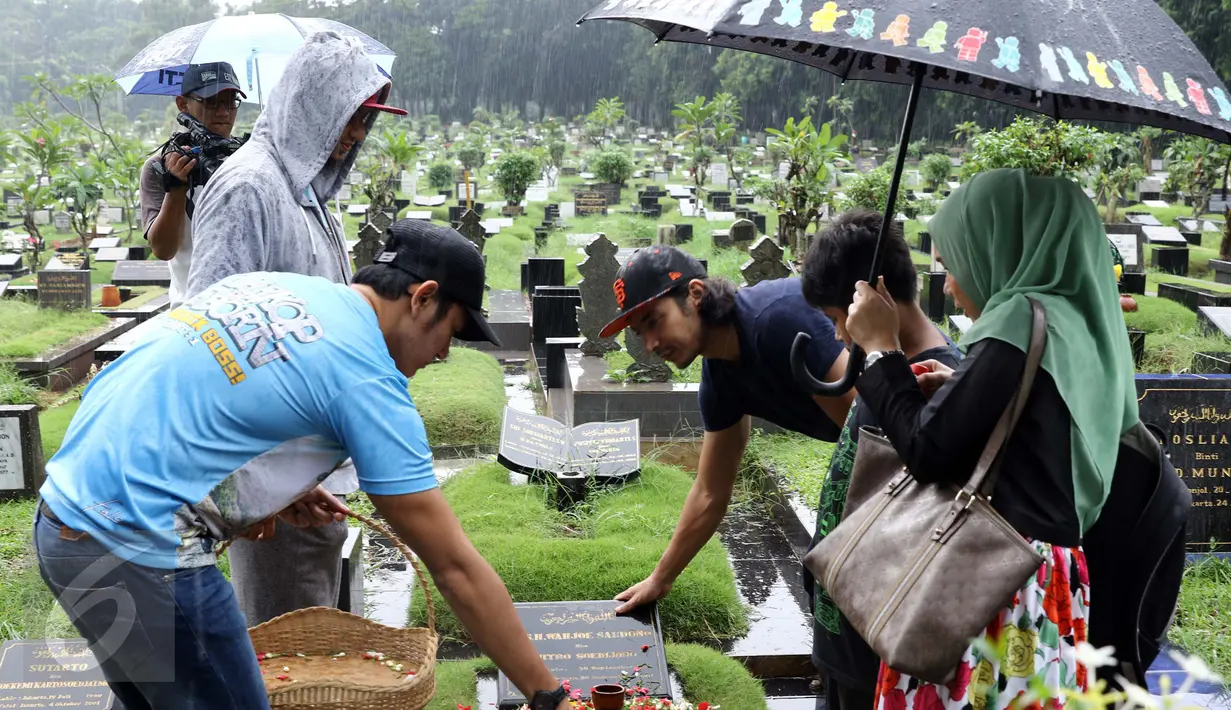 Pemain film Warkop DKI Reborn saat berziarah ke makam almarhum Dono di TPU Tanah Kusir, Bintaro, Jakarta, Sabtu (27/8). Ketiga pemain Dono, Kasino, dan Indro berziarah ke makam Dono dan Kasino. (Liputan6.com/Helmi Afandi)
