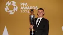 Gelandang Manchester City, Phil Foden berpose dengan trofi penghargaan Pemain Terbaik Pria versi Asosiasi Pemain Sepak Bola Profesional (PFA) di Opera House Manchester, Inggris, Selasa (20/8/2024). (Peter Byrne/PA via AP)