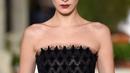 Model Bella Hadid berjalan di atas catwalk mengenakan koleksi terbaru dari Oscar de la Renta dalam New York Fashion Week, AS (12/2). Bella Hadid tampil cantik dengan gaun hitam panjang tanpa lengan. (AFP Photo/Slaven Vlasic)