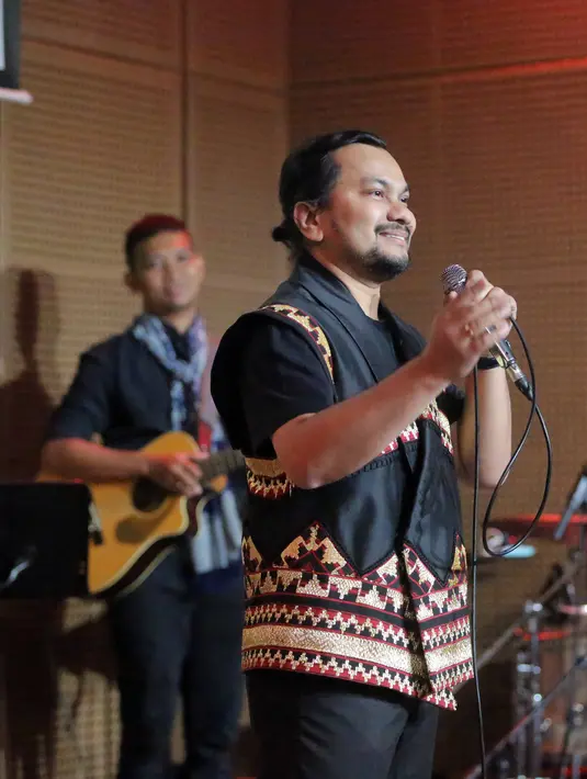 Senyum lebar Tompi sebagai putera Nanggroe menandakan kebanggan dengan lagu yang dibawakannya. Alunan musik keyboard, bass cello, drum, dan kendang terdengar harmonis dengan paduan tata panggung yang dinamis. [Foto: Bambang E Ros/Fimela.com]