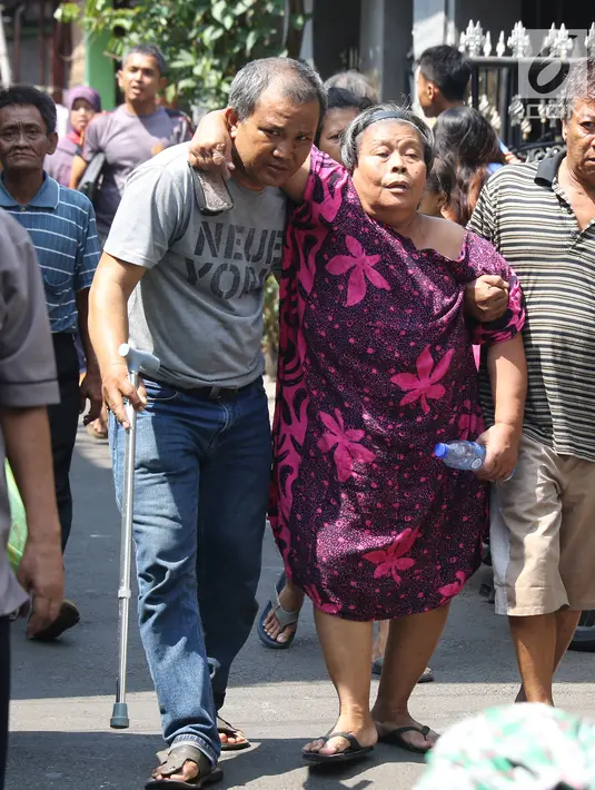 Warga berusaha menyelamatkan diri dari kebakaran yang melanda permukiman padat penduduk di Manggarai, Jakarta, Rabu (10/7/2019). Hingga saat ini sebanyak 28 unit mobil pemadam kebakaran dikerahkan di lokasi kejadian yang tak jauh dari Stasiun Kereta Api. (Liputan6.com/Herman Zakharia)