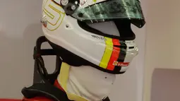 Pembalap Ferrari Sebastian Vettel dari Jerman memakai helmnya selama latihan bebas pertama di Sirkuit Internasional Formula One Bahrain di Sakhir, Bahrain, (6/4). Sebelumnya, Sebastian Vettel menjuarai balapan F1 GP Australia. (AP Photo/Luca Bruno)