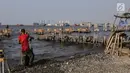 Pekerja menyelesaikan pondasi dermaga di Muara Angke, Jakarta Utara, Rabu (3/7/2019). Pembangunan dermaga tersebut untuk melindungi kapal-kapal yang bersandar di dermaga dari hantaman ombak besar. (Liputan6.com/Faizal Fanani)
