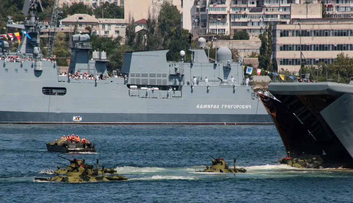 Sejumlah tank yang berisikan anggota marinir keluar dari kapal perang Rusia yang berlayar selama parade Hari Angkatan Laut di Sungai Neva, Saint Petersburg, Rusia, Minggu (29/7). (Kirill Kudryavtsev/AFP)