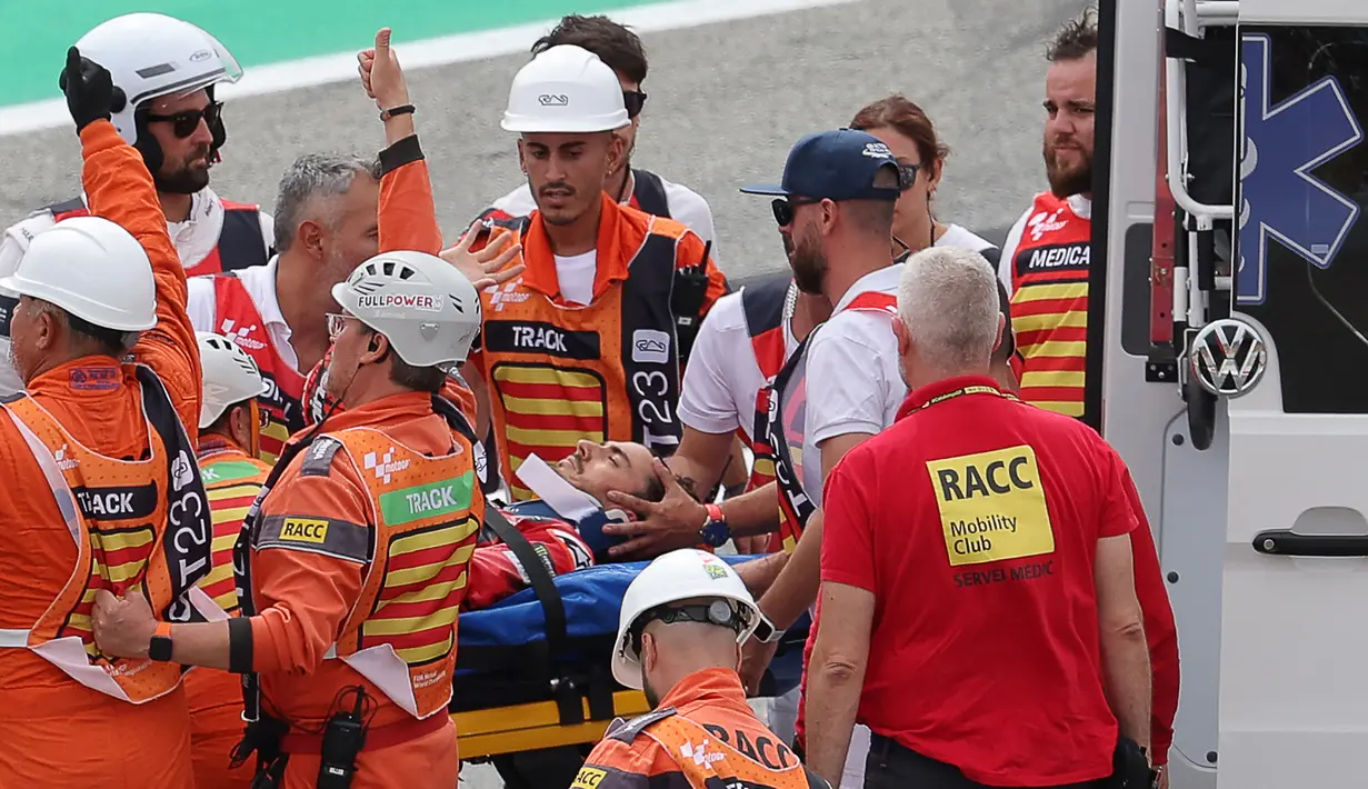 Pembalap Ducati Lenovo, Francesco Bagnaia, diangkut menggunakan tandu oleh sejumlah petugas medis setelah mengalami kecelakaan pada Tikungan 2 di Sirkuit Catalunya, Barcelona, Minggu (3/9/2023). (AFP/Lluis Gene)
