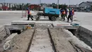 Pekerja membawa mesin disel saat pembongkaran beton rel kereta utama di Pelabuhan Tanjung Priok, Jakarta, Jumat (11/9/2015). Penutupan jalur kereta oleh Pelindo II membuat tidak efisiensi waktu bongkar pasang. (Liputan6.com/Gempur M Surya)