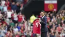 Mengenakan jas berwarna hitam, Raphael Varane menyapa fans di Old Trafford dengan membawa jersey Manchester United. Dia mendapat sambutan meriah dari fans yang memadati Old Trafford. (Foto: AP/Jon Super)