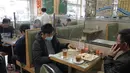 Pengunjung saat makan siang ditutupi panel plastik transparan untuk mengisolasi satu sama lain guna mencegah penyebaran virus corona di Hong Kong, Rabu, (12/2/2020). Per hari ini, Rabu (12/2) tercatat korban meninggal dunia akibat virus corona di China tercatat mencapai 1.110. (AP Photo/Kin Cheung)