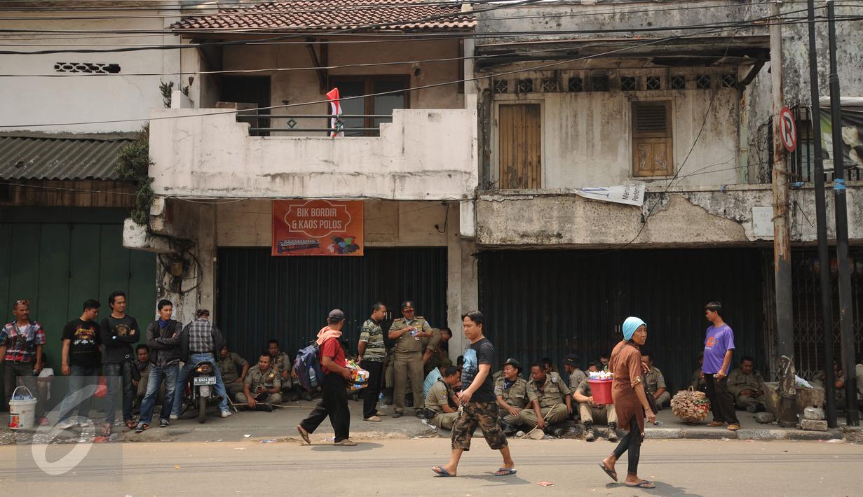 Warga melintas di depan toko yang ada di Jalan Jatinegara Barat,  Jakarta, Jumat (21/8/2015). Penutupan terkait proses penggusuran warga yang tinggal di sekitar bantaran Kali Ciliwung di Kampung Pulo Jakarta Timur. (Liputan6.com/Helmi Fithriansyah)